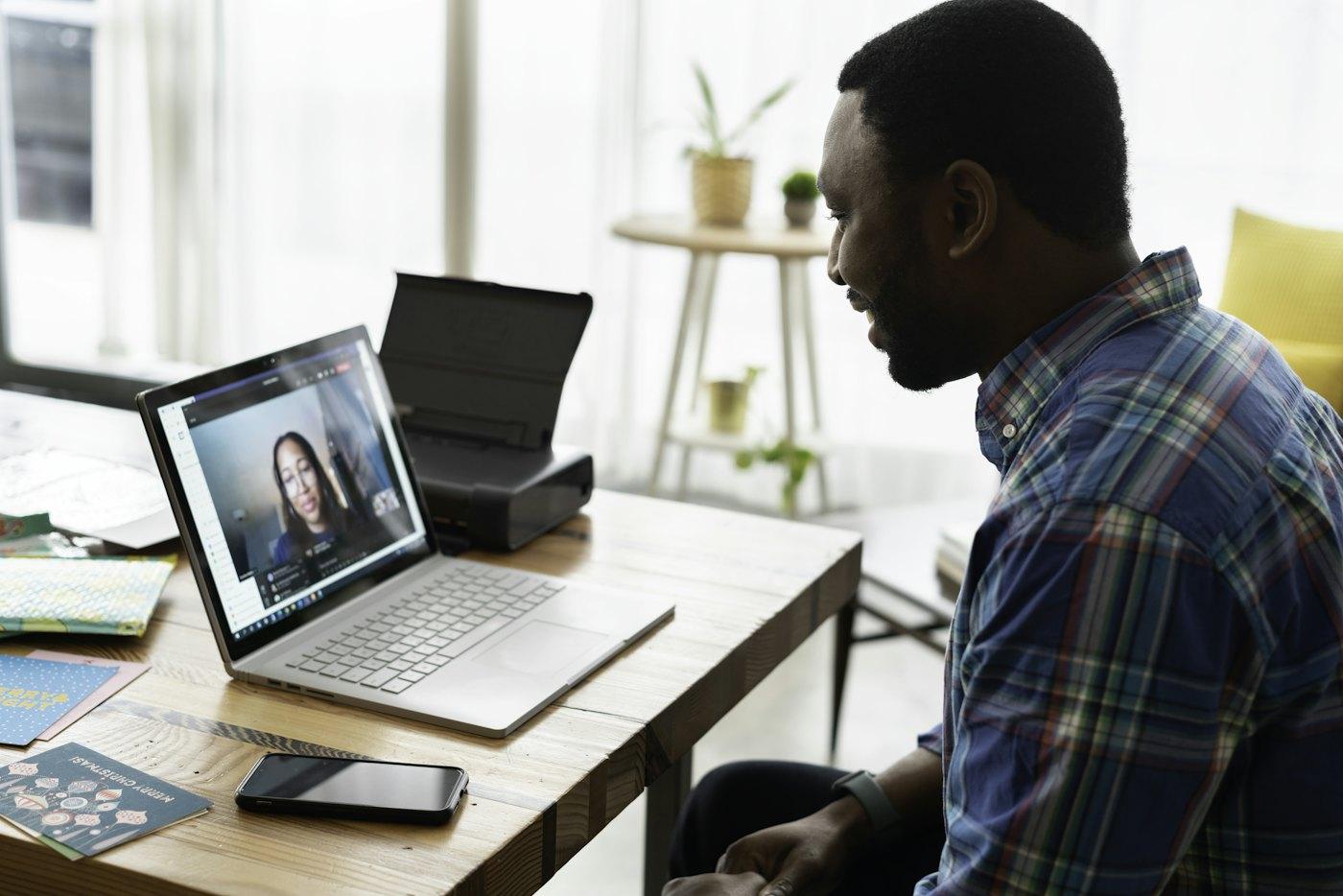 A man meeting with his provider by secure video from his home desk